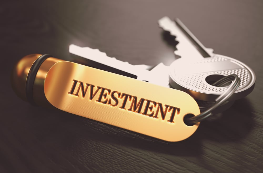 Keys with Word Investment on Golden Label over Black Wooden Background. Closeup View, Selective Focus, 3D Render. Toned Image.