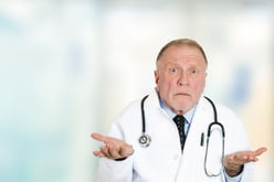Closeup portrait clueless senior health care professional doctor with stethoscope, has no answer, doesnt know right diagnosis standing in hospital hallway isolated clinic office windows background.